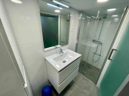 a white bathroom with a sink and a shower at Utsa Eski -Piso con encanto en 1ª linea de puerto in Bermeo