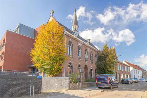 a red brick building with a church with a steeple at Klooster Mariadal Maastricht in Maastricht