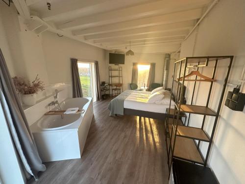 a bathroom with a bed and a tub and a sink at Hotel de Watertoren in Dordrecht