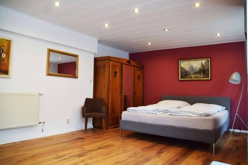 a bedroom with a bed and a red wall at Maison Harzliesel in Harzgerode