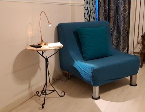 a blue chair sitting next to a table with a lamp at Al 68 Di Piazza Cavour in Naples