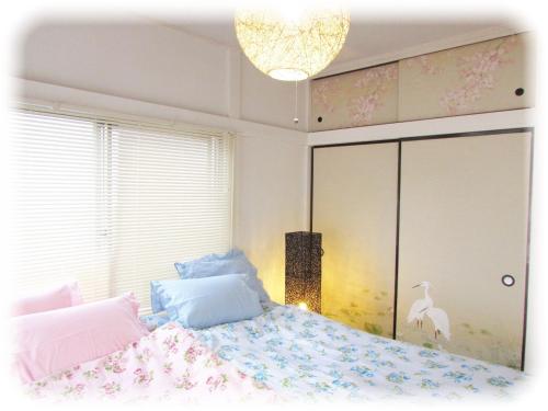 een slaapkamer met een bed en een kroonluchter bij Takano Private Rental House - Vacation STAY 32311v in Tokyo