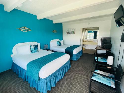 two beds in a hotel room with blue walls at Big Pine Key Motel in Big Pine Key