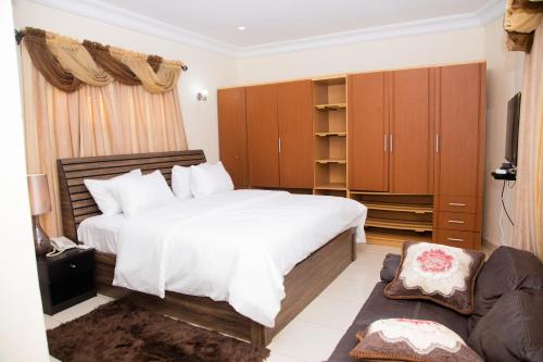 sypialnia z dużym białym łóżkiem i kanapą w obiekcie VelvetRose Cottage w mieście Araromi