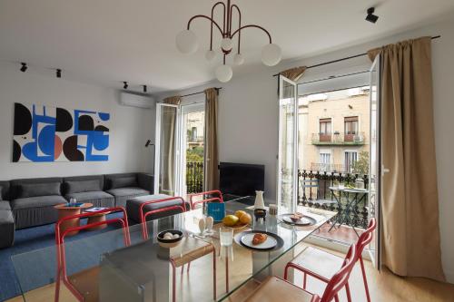 a living room with a glass table and red chairs at Rocafort in Eixample in Barcelona