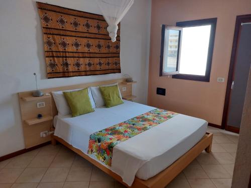 a bedroom with a large white bed with green pillows at Ca Bonita in Sal Rei