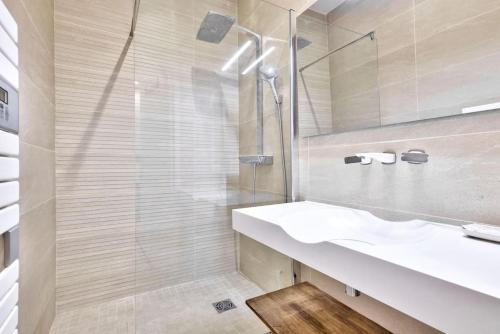 een witte badkamer met een wastafel en een spiegel bij Magnifique T2 dans l'hyper centre - rue d'Antibes in Cannes
