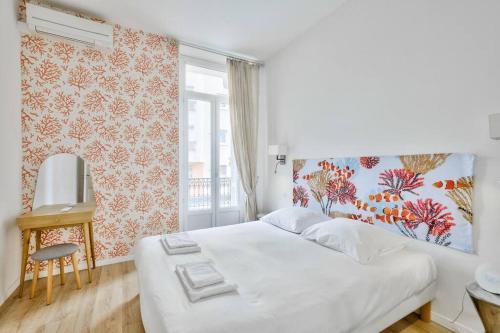een slaapkamer met een wit bed en een raam bij Magnifique T2 dans l'hyper centre - rue d'Antibes in Cannes