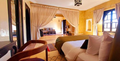 a bedroom with a bed and a living room at Kasbah ATFEL in Ourika