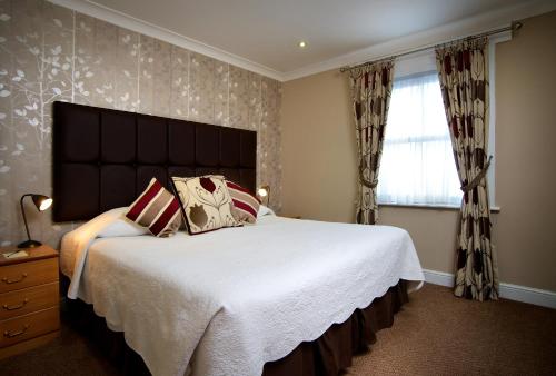 a bedroom with a large bed and a window at Langham Hotel Eastbourne in Eastbourne