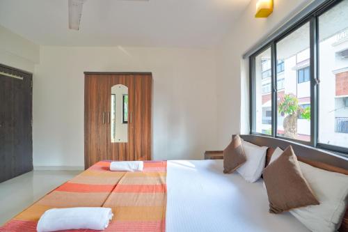 - une chambre avec un grand lit et une fenêtre dans l'établissement Amazing Pool View Candolim Goa 2BHK Apartment, à Candolim