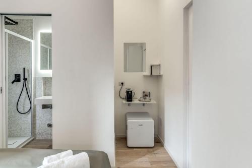 a white bathroom with a shower and a toilet at Vatican Portrait Suites in Rome