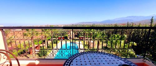 a balcony with a fence and a chair and mountains at Kasbah ATFEL in Ourika