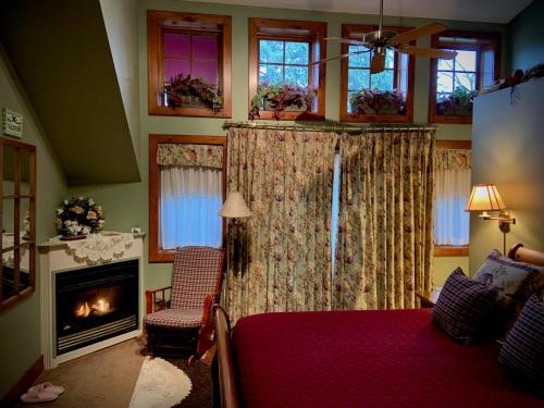 um quarto com uma lareira, uma cama e uma lareira em WeatherPine Inn em Niagara on the Lake