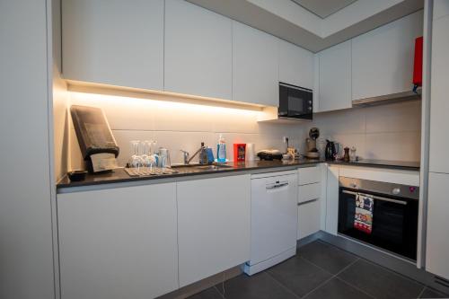 a small kitchen with white cabinets and a sink at Sublime Coliseum in Ponta Delgada