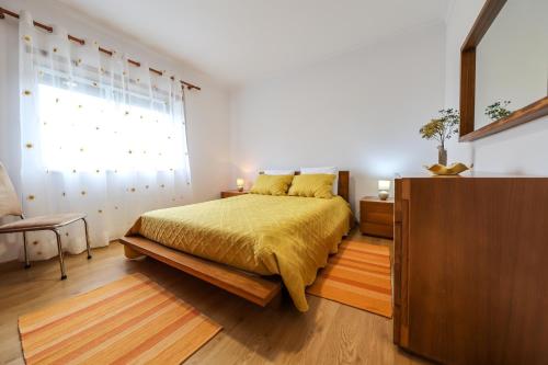 a bedroom with a bed and a large window at Casas com Amoras in Serra da Pescaria in Famalicão