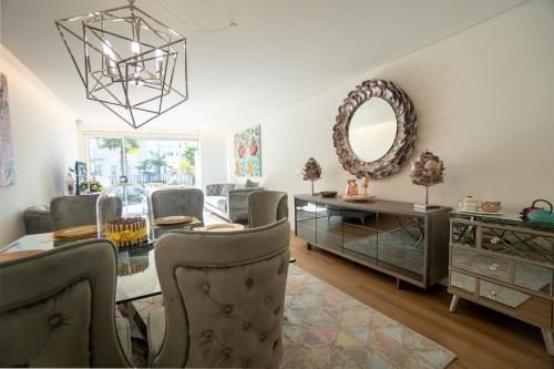 a dining room with a table and chairs and a mirror at Sublime Coliseum in Ponta Delgada