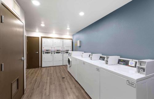 a laundry room with white appliances and blue walls at Extended Stay America Select Suites - Birmingham - Bessemer in Bessemer
