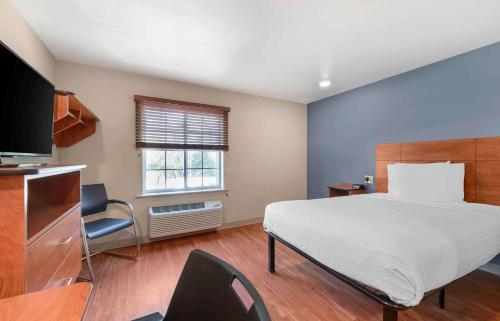 sypialnia z dużym łóżkiem i telewizorem w obiekcie Extended Stay America Select Suites - Colorado Springs w mieście Colorado Springs