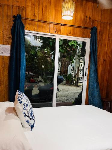 a bedroom with a bed and a sliding glass door at Blue House in Puerto Escondido