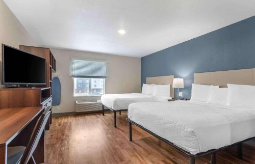 a hotel room with two beds and a flat screen tv at Extended Stay America Suites - Atlanta - Lithia Springs in Lithia Springs