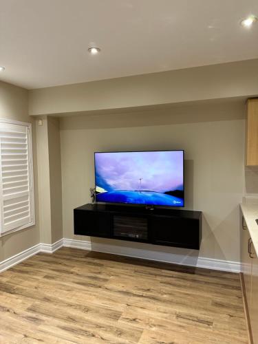 a living room with a flat screen tv on a wall at Beautiful Master bedroom unit with private washroom in Mississauga