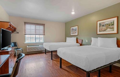 a room with two beds and a flat screen tv at Extended Stay America Select Suites - Indianapolis - Greenwood in Greenwood
