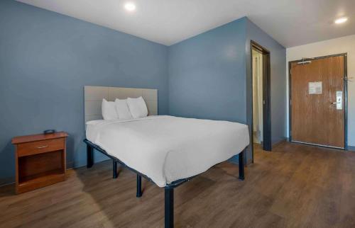niebieska sypialnia z łóżkiem i drewnianą podłogą w obiekcie Extended Stay America Select Suites - Phoenix - Peoria - Sun City w mieście Peoria