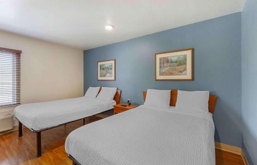 2 letti in una camera con pareti blu di Extended Stay America Select Suites - Akron - South a Portage Lakes