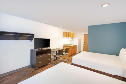 a bedroom with a bed and a desk with a tv at Extended Stay America Select Suites - Bentonville in Bentonville