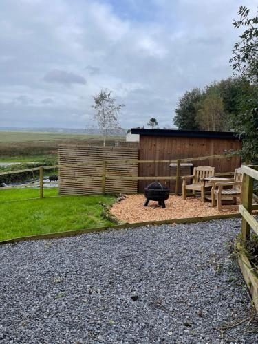 a backyard with a fire pit and a fence at The Rhossili bay secret in Swansea