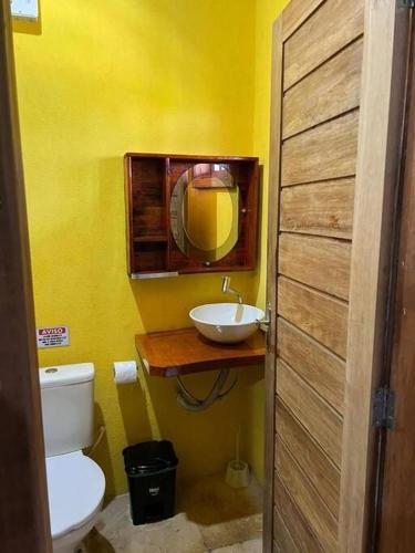 uma casa de banho com um lavatório, um WC e um espelho. em Casa amarela flecheiras em Trairi