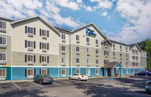 a large building with cars parked in a parking lot at Extended Stay America Select Suites - Charleston - Ashley Phosphate Rd in Hanahan