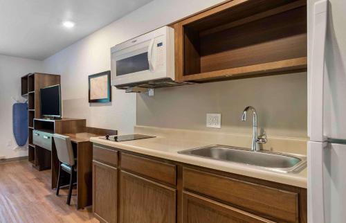 eine Küche mit einer Spüle und einer Mikrowelle in der Unterkunft Extended Stay America Suites - Charlotte - Matthews in Charlotte