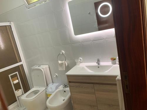 biała łazienka z toaletą i umywalką w obiekcie Casa 212 w mieście Ponta do Sol