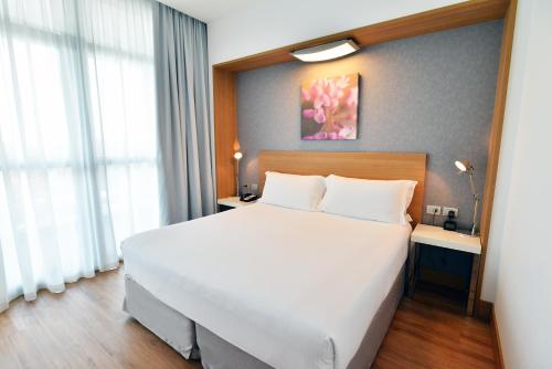 a bedroom with a large white bed and a window at Hilton Garden Inn Milan North in Milan