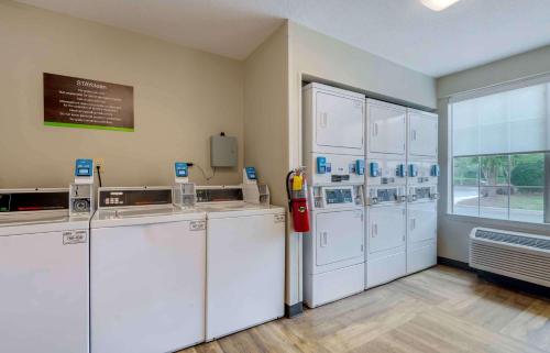 una habitación con un montón de máquinas blancas en una habitación en Extended Stay America Select Suites - Charlotte - Airport, en Charlotte
