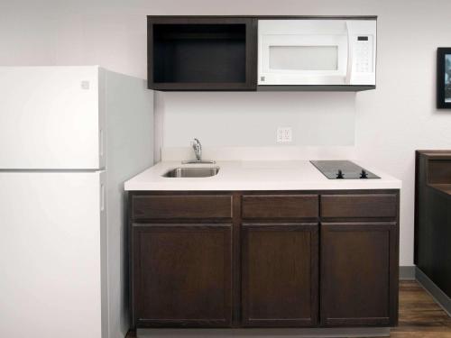 una pequeña cocina con fregadero y microondas en Extended Stay America Select Suites - Fayetteville, en Fayetteville