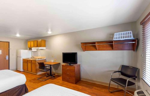 a room with a bed and a desk with a television at Extended Stay America Select Suites - Denver - Aurora in Aurora