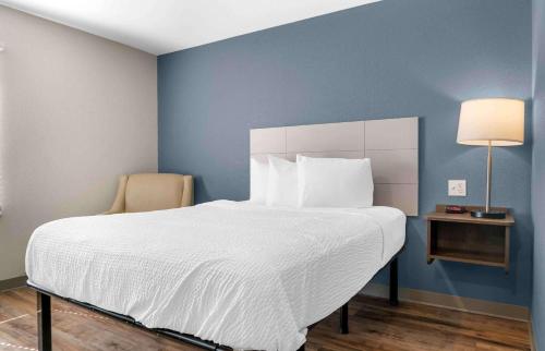 a bedroom with a large bed with a blue wall at Extended Stay America Suites - Detroit - Rochester Hills in Rochester Hills