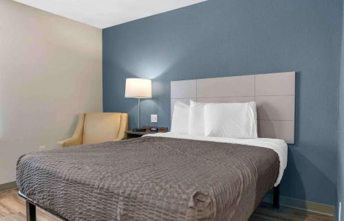 a bedroom with a large bed and a blue wall at Extended Stay America Suites - Detroit - Rochester Hills in Rochester Hills