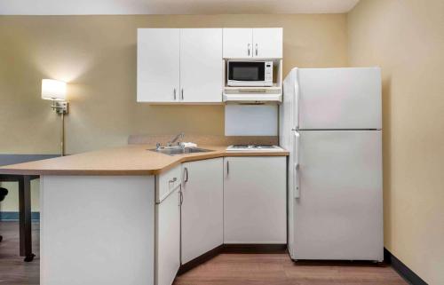 a kitchen with white cabinets and a white refrigerator at Extended Stay America Suites - Philadelphia - Cherry Hill in Maple Shade