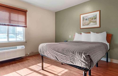 uma cama num quarto com uma janela e uma cama sidx sidx em Extended Stay America Select Suites - Cincinnati - Florence - Airport em Florence