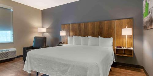 a bedroom with a large white bed and a chair at Extended Stay America Premier Suites - Savannah - Pooler in Savannah