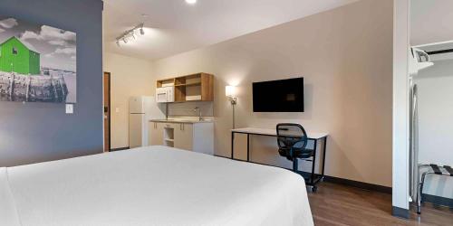 a bedroom with a white bed and a desk with a computer at Extended Stay America Premier Suites - Savannah - Pooler in Savannah