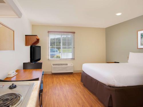 um pequeno quarto de hotel com uma cama e uma cozinha em Extended Stay America Select Suites - Birmingham - Pelham em Pelham