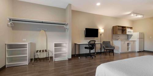 a bedroom with a bed and a desk with a surfboard at Extended Stay America Premier Suites - Savannah - Pooler in Savannah