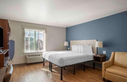1 dormitorio con 1 cama grande y 1 silla en Extended Stay America Suites - Charlotte - Northlake, en Charlotte