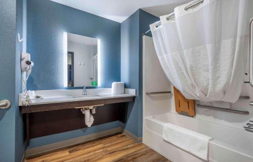 ein Badezimmer mit einem Waschbecken, einer Badewanne und einem Spiegel in der Unterkunft Extended Stay America Suites - Charlotte - Northlake in Charlotte