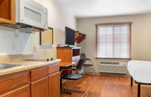 a kitchen with a sink and a desk with a microwave at Extended Stay America Select Suites - Grand Rapids - Wyoming in Wyoming